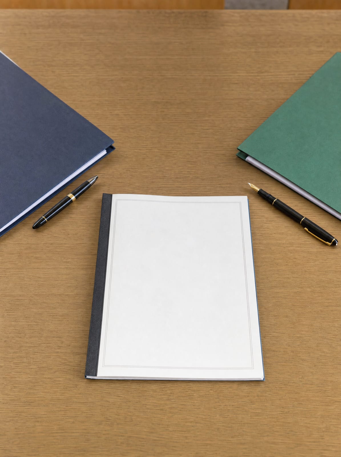 A bound licensing or franchise agreement on a wood desk with two fountain pens and two folders set opposite each other, representing an agreement between parties