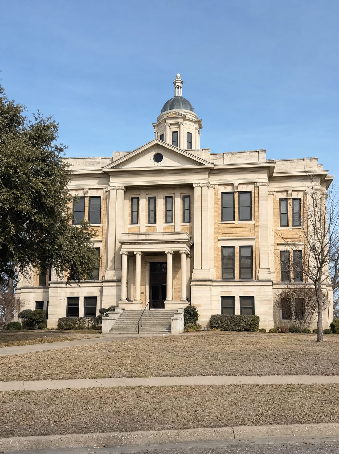 A stately Texas county courthouse of limestone and brick with stone steps and columns, for an appeal to district court
