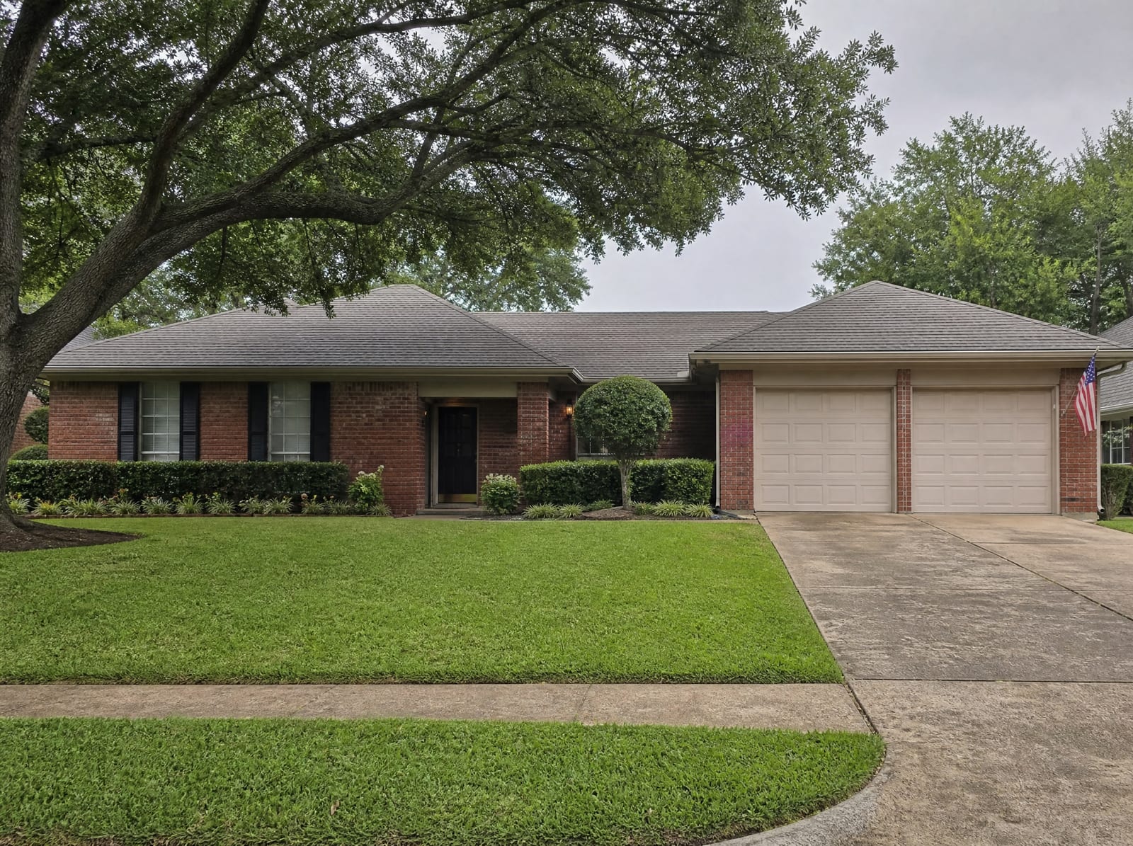 A comfortable established single-story brick Texas family home with a garage, mown lawn, and mature trees, the assets a trust helps protect