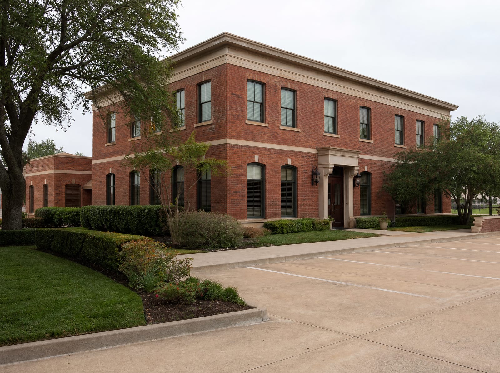 An established, well-kept family-owned Texas business, a handsome two-story red-brick commercial building with tidy landscaping and a clean parking area, the kind of enterprise passed down through generations