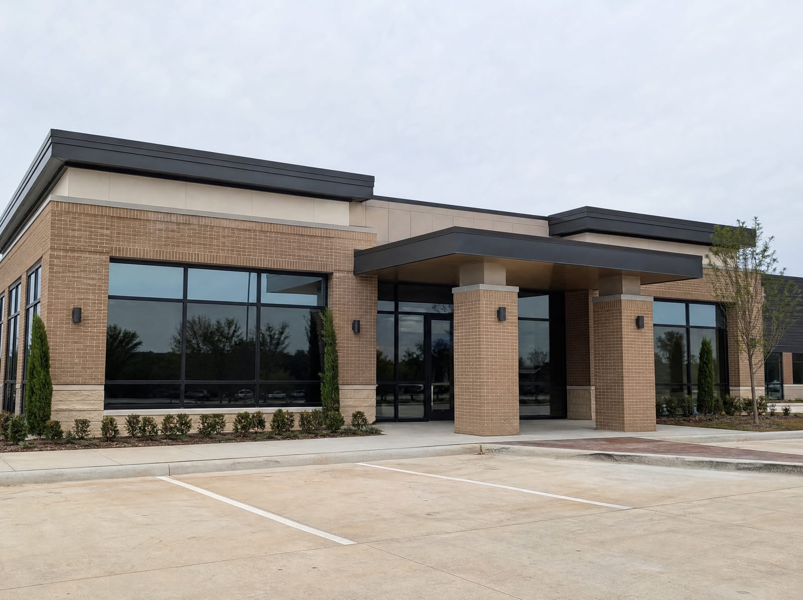 A clean, modern Texas commercial building with a brick and glass facade, a covered entrance, and a well-kept parking lot
