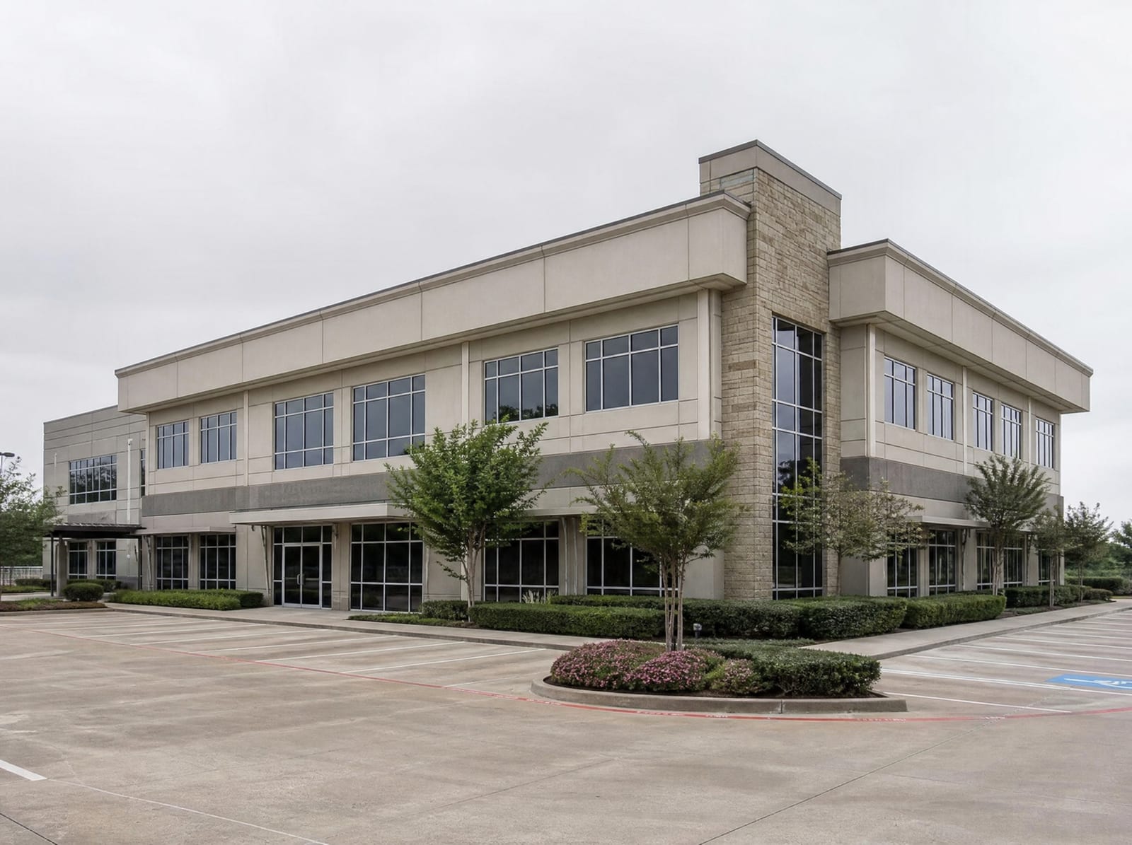 A clean modern two-story Texas professional office building with glass storefronts and a well-kept parking lot